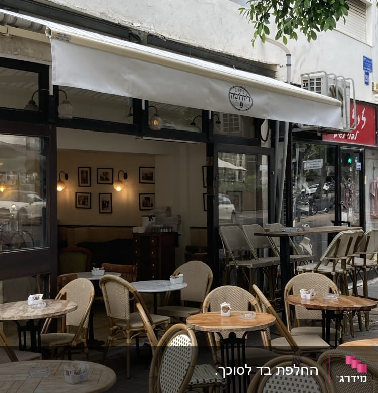 סוכך לבן פתוח מעל בית קפה